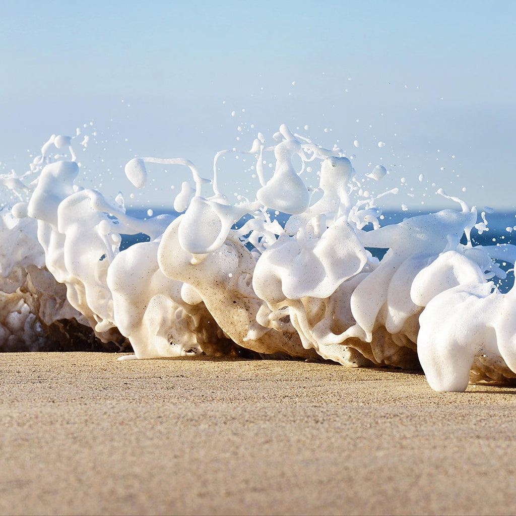 Ocean wave art of gorgeous and playful foam bouncing on the shore’s sand.