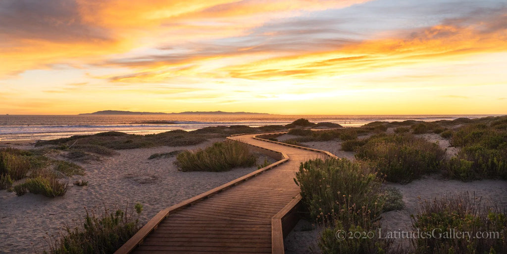 Glowing orange sunset over the ocean on the seaside walking path of the Ventura promenade.