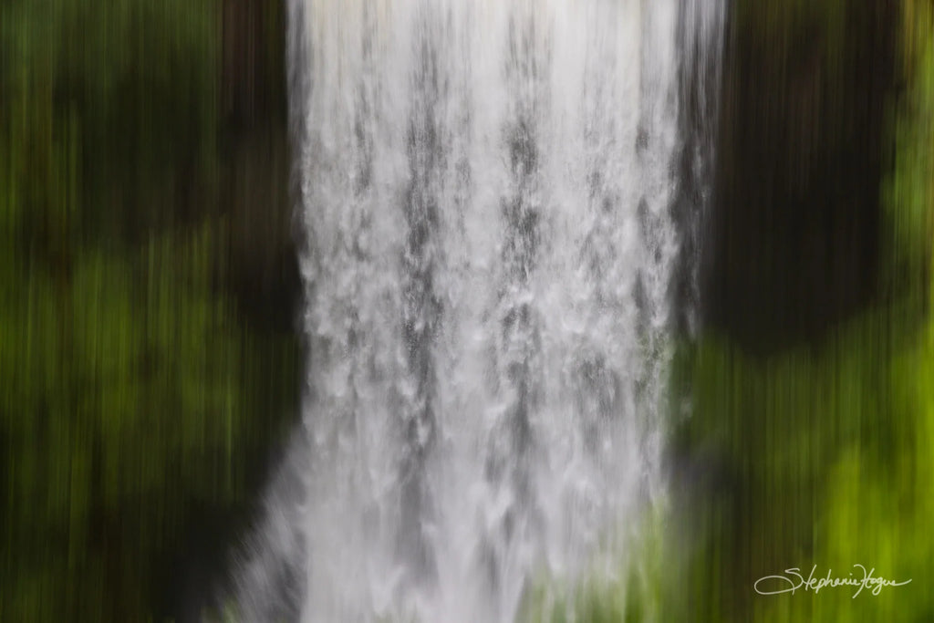 A dreamy waterfall in abstract form surrounded by luscious greenery.